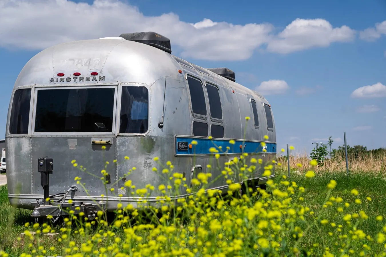 Restored vintage Airstream trailer exterior in a Texas wildflower field